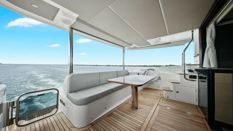 Slide: The Image of Spacious Aft Deck with Seating Area The aft deck of the 2024 Absolute 52 Navetta features an inviting seating area with elegant teak flooring. The plush L-shaped bench and sleek wooden table offer a perfect setting for alfresco dining or relaxing while enjoying panoramic ocean views. The op - 6851793