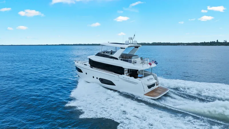 Slide: The Image of Aerial View of 52 Navetta Stern The 2024 Absolute 52 Navetta 'One More' showcases a sleek, modern design as it glides effortlessly through open waters. The spacious aft deck is highlighted, offering ample space for outdoor relaxation and entertainment. The yacht's elegant lines and powe - 6851862