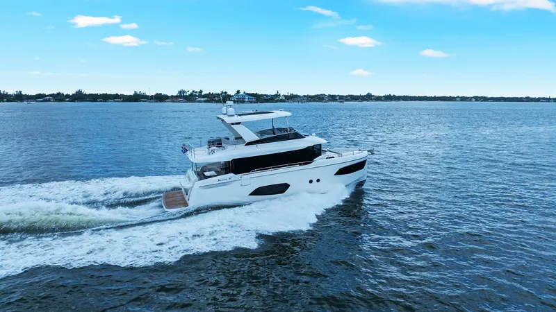 Slide: The Image of Side View of 52 Navetta in Motion The 2024 Absolute 52 Navetta, named 'One More,' glides effortlessly across the water, showcasing its sleek profile and modern design. The expansive flybridge and generous windows highlight the vessel's luxurious amenities and commitment to panoramic views - 6851856