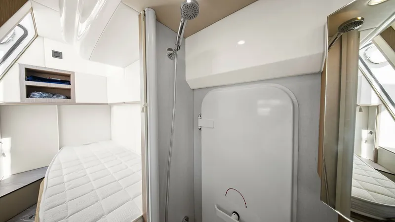 Slide: The Image of Guest Cabin with Ensuite Shower This modern guest cabin on the 2024 Absolute 52 Navetta features a comfortable berth with ample natural light from large windows. The ensuite shower area is elegantly integrated, providing convenience and privacy. Thoughtful storage solutions and sleek fi - 6851833