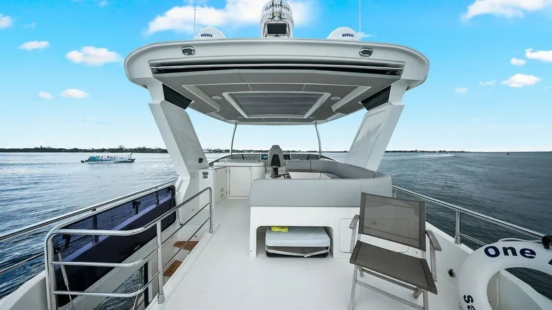 Slide: The Image of Flybridge Lounge Area This image showcases the inviting flybridge of the Absolute 52 Navetta. The spacious area features comfortable seating with a sleek design, perfect for social gatherings or relaxing while enjoying panoramic ocean views. The overhead canopy provides shade, - 6851770