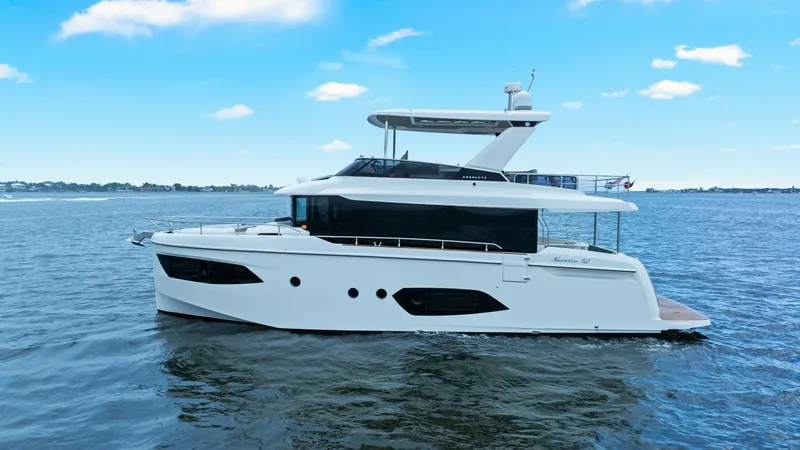 Slide: The Image of Starboard Side Profile View The Absolute 52 Navetta 'One More' showcases a sleek starboard profile, emphasizing its modern design and spacious flybridge. The elegant lines and expansive windows provide a luxurious aesthetic while enhancing onboard visibility. This 2024 model combine - 6851852