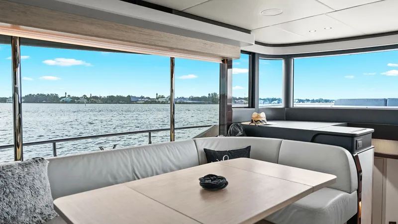 Slide: The Image of Salon with Panoramic Windows The salon of the 2024 Absolute 52 Navetta offers an inviting space with expansive panoramic windows, allowing for breathtaking views of the surrounding waters. The contemporary decor features plush seating and a sleek dining table, creating a perfect sett - 6851808