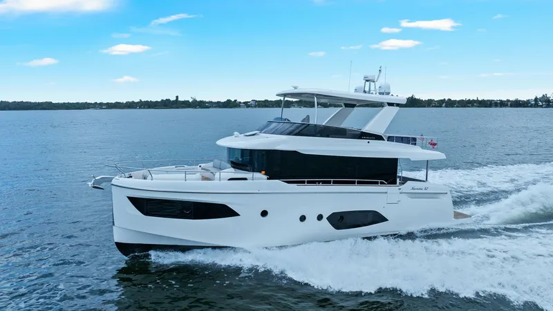 Slide: The Image of Side Profile of Absolute 52 Navetta This image showcases the sleek side profile of the 2024 Absolute 52 Navetta, named 'One More'. The vessel's modern design is highlighted by its streamlined hull and expansive windows, which promise panoramic views and abundant natural light. The upper dec - 6851864