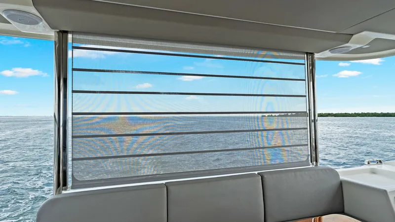 Slide: The Image of Salon with Ocean View Window This inviting salon on the 2024 Absolute 52 Navetta features a large, retractable window, providing stunning panoramic ocean views. The comfortable seating area is adorned with plush cushions, perfect for relaxation or entertaining. The use of high-qualit - 6851794