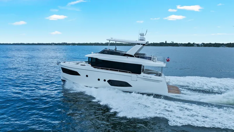 Slide: The Image of Side Profile Cruising View The 2024 Absolute 52 Navetta, 'One More', is shown cruising gracefully through open waters. Its sleek design and modern lines are complemented by large windows that promise ample natural light inside. The flybridge and spacious decks highlight the yacht's - 6851863