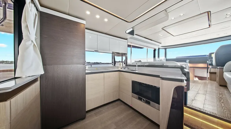 Slide: The Image of Modern Galley with Sea View This contemporary galley on the 2024 Absolute 52 Navetta features sleek cabinetry and top-of-the-line appliances, perfect for gourmet cooking while at sea. The light wood finishes and large windows create a bright and open atmosphere, offering stunning oc - 6851800