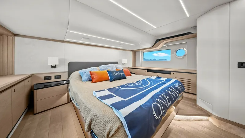 Slide: The Image of Master Stateroom with Panoramic Window This master stateroom aboard the 2024 Absolute 52 Navetta blends luxury and comfort, featuring a large bed with stylish bedding. The room is enhanced by sleek, modern lighting and ample storage space. A panoramic window offers stunning views, creating a s - 6851826