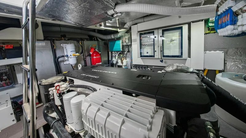 Slide: The Image of Engine Room with Modern Systems This image showcases the meticulously organized engine room of the Absolute 52 Navetta. The space features state-of-the-art propulsion systems, advanced control panels, and essential safety equipment, all arranged for optimal efficiency and maintenance ac - 6851839