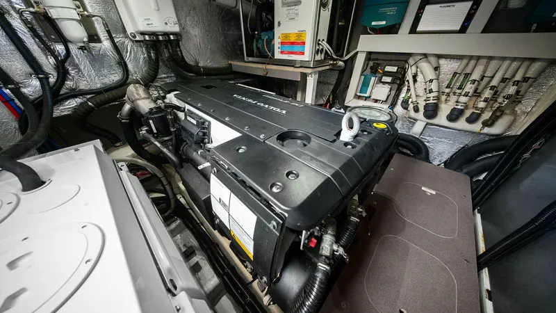 Slide: The Image of Engine Room with Modern Equipment The image showcases the well-organized engine room of the Absolute 52 Navetta, featuring state-of-the-art machinery and advanced control systems. The neatly arranged pipes and insulated surfaces highlight the meticulous engineering, ensuring optimal perfo - 6851843