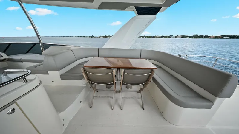 Slide: The Image of Flybridge Seating Area with Table The flybridge of the 2024 Absolute 52 Navetta features a spacious seating area with plush, wrap-around cushions and a sleek wooden table, perfect for alfresco dining. The area offers panoramic views, making it an ideal spot for relaxation and entertaining - 6851787
