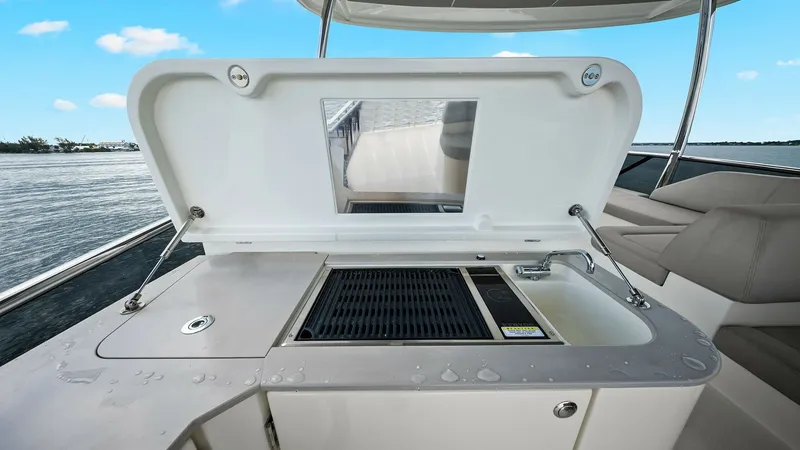 Slide: The Image of Flybridge Wet Bar with Grill This image showcases the sleek flybridge wet bar on the Absolute 52 Navetta, featuring a built-in grill and sink for convenient outdoor dining. The area is designed with modern finishes, providing a stylish and functional space for entertaining guests whi - 6851782