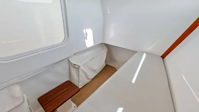 Slide: The Image of Cozy Cabin Seating Area This inviting cabin on The Sunshine Crew features a minimalist design with clean lines and bright finishes. The seating area is complemented by a compact wooden table, ideal for small gatherings or relaxation. The natural light streaming through the windo - 6834923