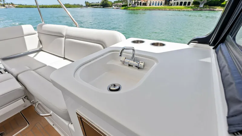 Slide: The Image of Cockpit Wet Bar and Seating Area The Sunshine Crew's cockpit features a well-appointed wet bar, complete with a sleek sink and convenient cup holders, perfect for entertaining guests. The adjacent plush seating offers comfort and style, providing an inviting space to relax and enjoy the - 6834935