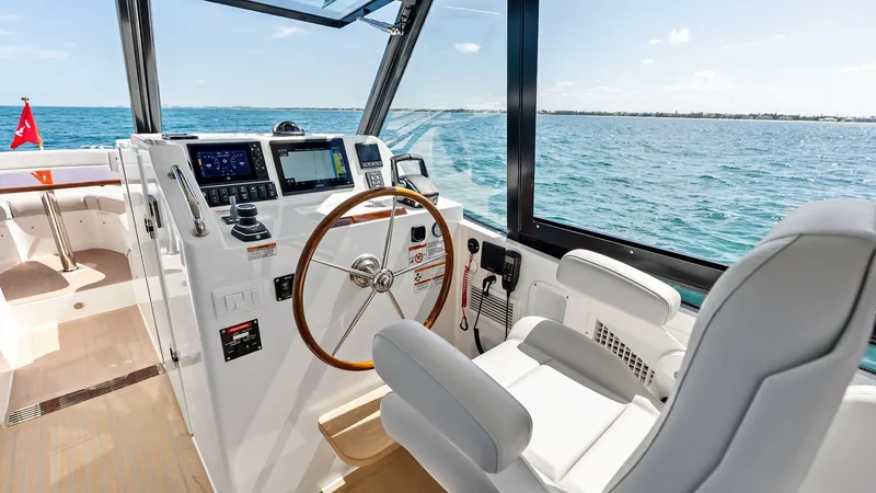 Slide: The Image of Helm Station with Ocean View The helm station of the 2025 MJM M3 is equipped with state-of-the-art navigation technology and a classic wooden steering wheel. The captain's chair offers ergonomic comfort, while large windows provide an expansive view of the ocean, enhancing the drivin - 6834914