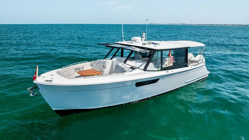 Slide: The Image of Starboard Side and Cockpit View This image showcases the sleek starboard side of the 2025 MJM M3, 'The Sunshine Crew.' The vessel features a spacious cockpit with comfortable seating, ideal for leisure and entertainment. Its modern design is complemented by a streamlined hull and large - 6834941