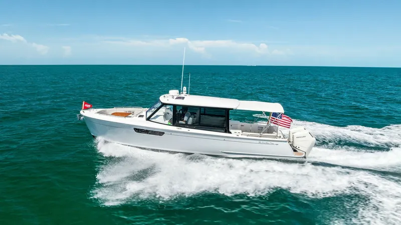 Slide: The Image of Side Profile Cruising View The Sunshine Crew, a 2025 MJM M3, elegantly cruises through open waters showcasing its sleek design and powerful performance. The vessel features a spacious open deck with a protective hardtop, perfect for enjoying the sea breeze while staying shaded. Its - 6834955