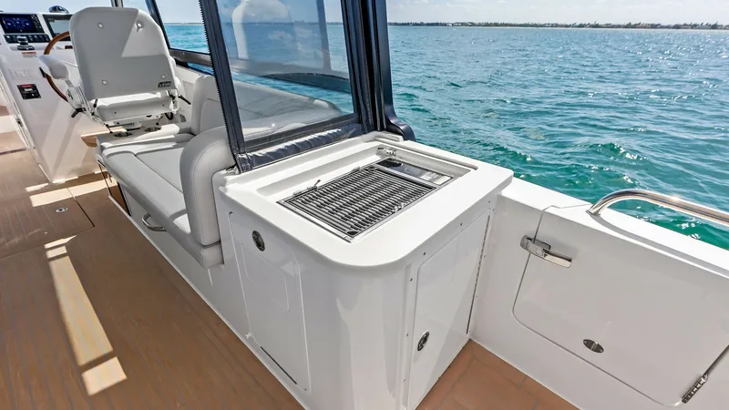 Slide: The Image of Cockpit Grill and Seating Area This image showcases the modern cockpit area of the MJM M3, featuring a sleek built-in grill perfect for entertaining. The adjacent comfortable seating provides a relaxing spot for guests to enjoy meals and the open ocean views. The high-quality finishes - 6834927