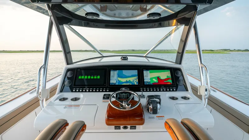 Slide: The Image of Helm Station with Advanced Navigation The helm station of the 2022 Valhalla Boatworks V-46 features state-of-the-art navigation technology, with multiple large display screens for comprehensive control and monitoring. The elegant steering wheel and throttle controls are set on a sleek, polish - 7162286