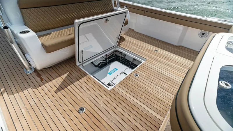 Slide: The Image of Aft Deck with Engine Access Hatch The aft deck of the 2022 Valhalla V-46 features a sleek teak finish, offering both style and durability. The open engine access hatch provides convenient access to mechanical systems, ensuring easy maintenance. Plush, diamond-stitched seating enhances com - 6845071