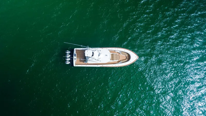 Slide: The Image of Aerial View of Valhalla V-46 This aerial shot captures the sleek design of the 2022 Valhalla V-46 by Valhalla Boatworks. The vessel's streamlined hull and spacious deck are complemented by powerful outboard engines, showcasing its capability for high-speed performance. The elegant te - 6845086