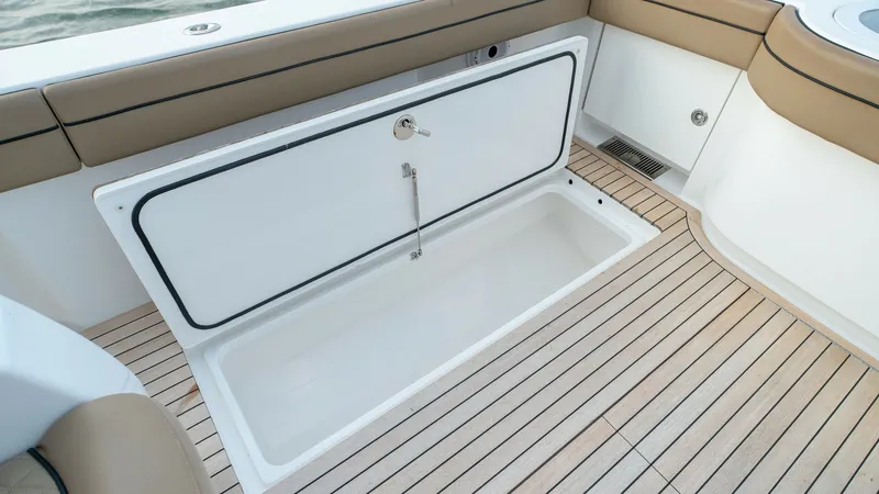 Slide: The Image of Aft Deck Storage Compartment The Valhalla V-46's aft deck features a spacious storage compartment, seamlessly integrated into the sleek design. The teak decking highlights the luxury finish, while cushioned seating along the edge provides comfort. This area is perfect for stowing gea - 7162297