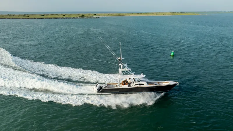 Slide: The Image of Aerial View of V-46 in Motion The 2022 MarMar by Valhalla Boatworks, Model V-46, is captured gracefully cutting through the water. Its sleek hull design and powerful outboard engines create an impressive wake, showcasing its strength and speed. The vessel's elegant lines and spacious - 7162323