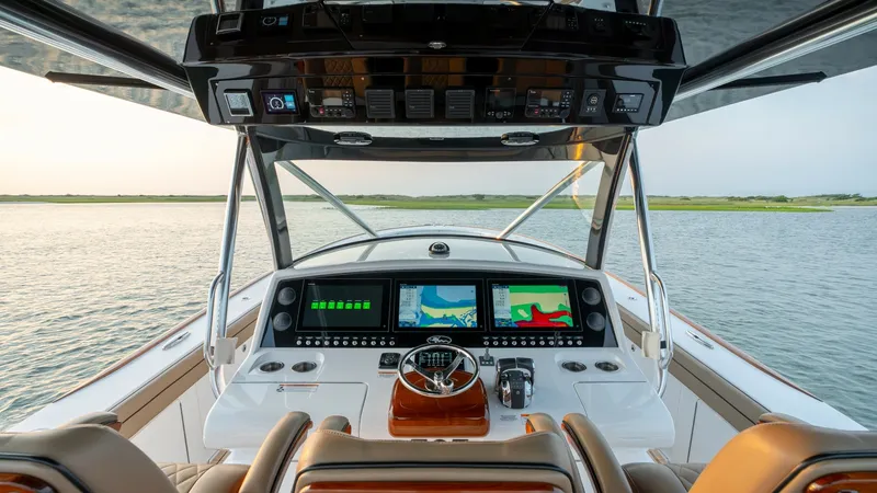 Slide: The Image of Helm Station with Dual Displays The helm station of the 2022 Valhalla Boatworks V-46 showcases state-of-the-art dual display screens for advanced navigation and monitoring. The sleek console is complemented by luxurious, leather-upholstered seating, offering both comfort and style. Over - 7162278