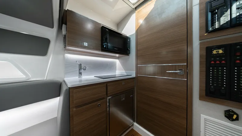 Slide: The Image of Galley with Modern Appliances The galley of the V-46 model by Valhalla Boatworks features sleek cabinetry and contemporary finishes, providing both style and functionality. Stainless steel appliances, including a microwave and refrigerator, are complemented by a polished countertop an - 7162310
