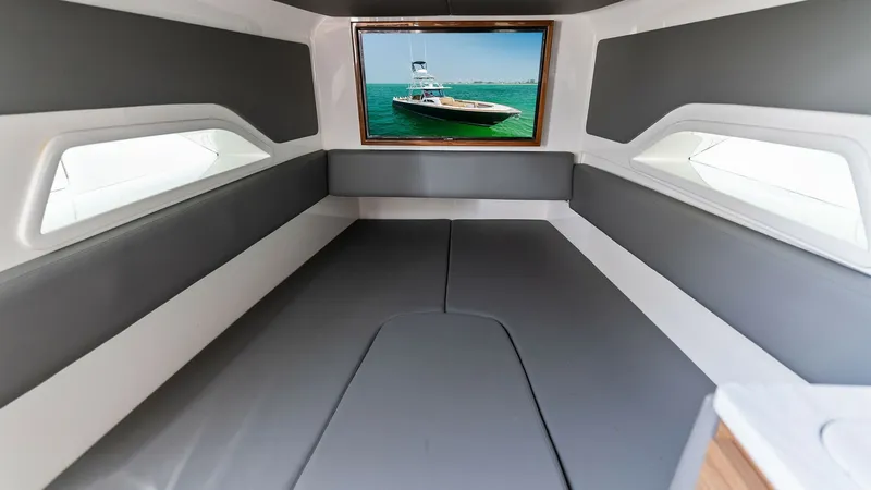Slide: The Image of Forward Cabin with Panoramic Window The forward cabin of the Valhalla V-46 offers a spacious and modern interior, highlighted by a large panoramic window that provides stunning views of the sea. The seating area is upholstered in sleek, gray materials, creating a comfortable and stylish spa - 6845078