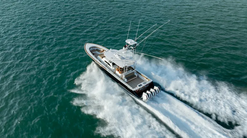 Slide: The Image of Aerial View of V-46 in Motion The Valhalla Boatworks V-46, model year 2022, is seen gracefully slicing through the water with its powerful quad engines. This dynamic aerial shot showcases the vessel's sleek design and spacious deck, perfect for both fishing and leisure. The turquoise - 7162335