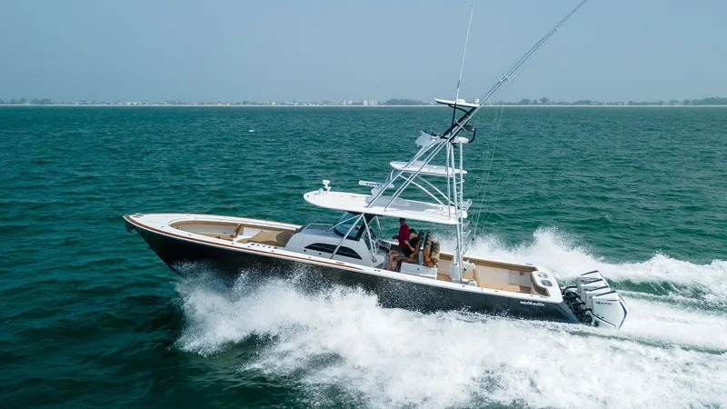 Slide: The Image of Dynamic Aerial View of V-46 in Motion This aerial shot captures the Valhalla Boatworks V-46 slicing through the water with grace and power. The sleek hull design and triple outboard engines underscore its performance capabilities, while the flybridge offers a commanding view for navigating op - 6845095