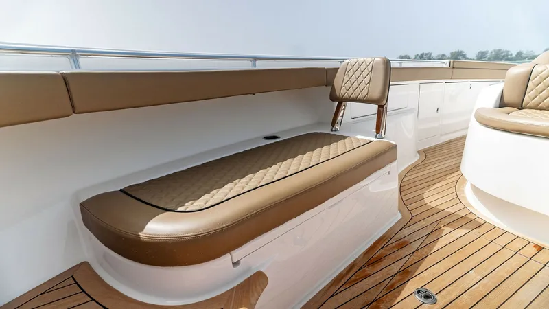 Slide: The Image of Spacious Aft Deck Seating Area This image showcases the inviting aft deck seating area of the 2022 Valhalla Boatworks V-46, featuring elegant, cushioned seating with quilted detailing. The teak flooring adds a touch of luxury, complementing the sleek white and tan color scheme. The amp - 6845065