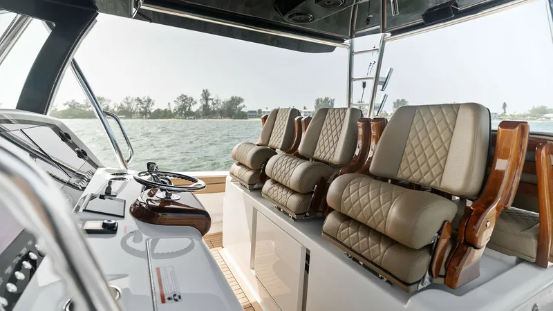 Slide: The Image of Helm Station with Luxurious Seating The helm station of the 2022 MarMar V-46 by Valhalla Boatworks showcases premium seating with diamond-stitched leather cushions, offering both style and comfort for long voyages. The sleek navigation console is equipped with advanced controls and displays - 6845066