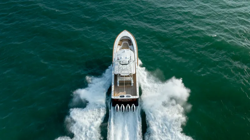 Slide: The Image of Aerial View of Yacht in Motion This striking aerial view captures the Valhalla Boatworks V-46, MarMar, gliding smoothly through the water. The vessel's powerful quad outboard engines are showcased, leaving a dynamic wake behind. The sleek design and spacious deck highlight the yacht's - 7162339