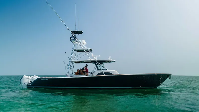 Slide: The Image of Side Profile of V-46 at Sea This image showcases the sleek side profile of the 2022 Valhalla Boatworks V-46, named MarMar, gliding effortlessly on open waters. The vessel features a striking black hull with a spacious deck, perfect for both leisure and sport fishing. The elevated to - 6845082