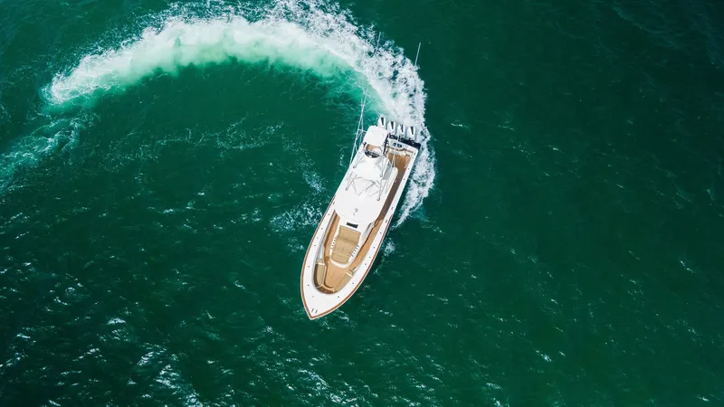 Slide: The Image of Aerial View of V-46 in Motion This aerial shot captures the sleek and powerful Valhalla Boatworks V-46 navigating pristine waters with precision. The vessel's elegant design is highlighted by its streamlined hull and spacious deck, perfect for both leisure and performance. The wake pa - 6845091