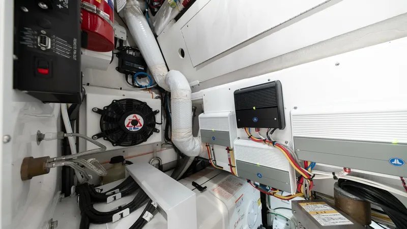 Slide: The Image of Engine Room with Electrical Systems The engine room of the 2022 Valhalla V-46, featuring a neatly organized array of electrical systems and components. The layout emphasizes efficient use of space, with wires and conduits expertly arranged for easy access and maintenance. High-quality mater - 7162317