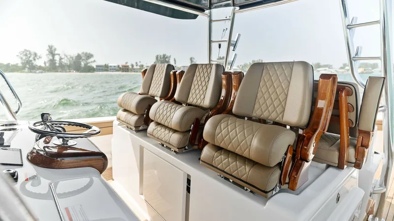 Slide: The Image of Helm Seating with Luxurious Finishes The helm of the Valhalla V-46 features plush, diamond-stitched seating, offering both comfort and style for the captain and crew. The rich wood accents complement the elegant upholstery, creating a refined atmosphere. With a commanding view and easy acces - 6845060
