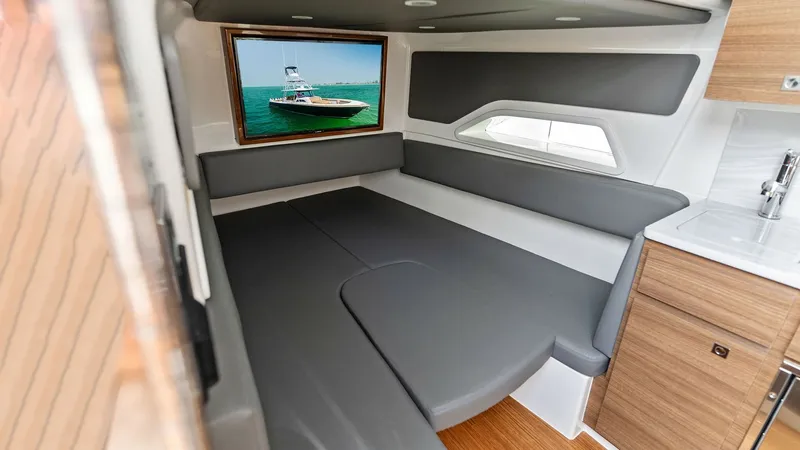 Slide: The Image of Compact Cabin with Daybed This cozy cabin in the 2022 Valhalla Boatworks V-46 features a sleek daybed surrounded by modern, gray upholstery. The space is enhanced by a wide window, allowing natural light to flood in and offering a view of the surrounding seascape. The cabin's cont - 6845079