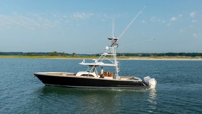 The Image of Side View of V-46 at Sea The Valhalla Boatworks V-46, model year 2022, is shown cruising smoothly on open waters. This elegant vessel features a sleek black hull with a spacious deck designed for comfort and performance. The sturdy tower and twin outboard engines underscore its c - 7162277