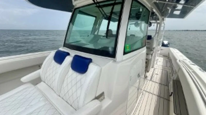 Slide: The Image of Helm Area with Forward Seating This image showcases the helm area of the 2018 Hydra-Sports 4200 Siesta, featuring plush forward seating with elegant diamond-stitched upholstery. The large, tinted windshield provides excellent visibility while offering protection from the elements. The - 7030831
