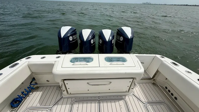 Slide: The Image of Aft Deck with Quad Engines The aft deck of the 2018 Hydra-Sports 4200 Siesta features a robust setup with four powerful outboard engines, ideal for high-speed cruising and offshore adventures. The deck is equipped with a central storage compartment and dual livewells, perfect for f - 7030817