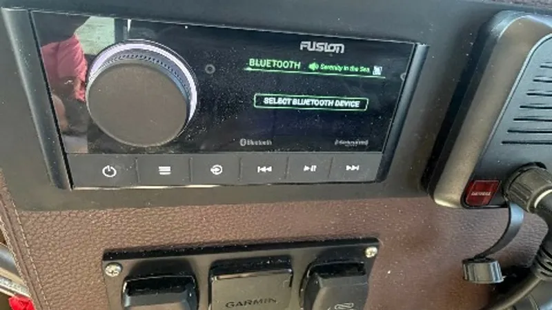 Slide: The Image of Dashboard Entertainment System The image showcases the sophisticated Fusion entertainment system on the 2014 Regal 46 Sport Coupe, 'Serenity in the Sea'. This state-of-the-art system offers Bluetooth connectivity for seamless audio streaming, enhancing the onboard experience. The ergon - 6857448