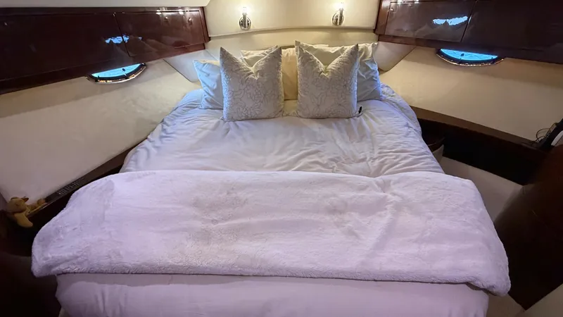 Slide: The Image of Luxurious Forward Stateroom Experience ultimate comfort in the forward stateroom of the 2014 Regal 46 Sport Coupe. Featuring a plush double berth with crisp linens and accent pillows, this space offers a tranquil retreat. The rich wood finishes and soft ambient lighting enhance the - 6857429