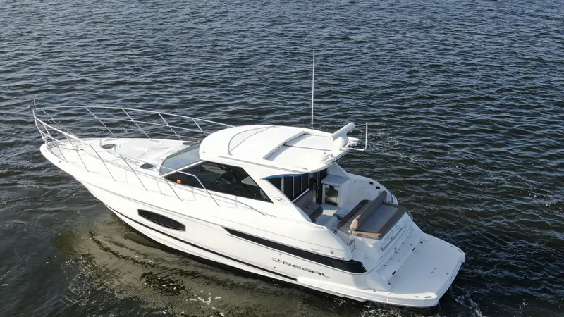 Slide: The Image of Aerial View of Stern and Deck This aerial shot showcases the elegant stern of the 2014 Regal 46 Sport Coupe. The spacious swim platform and sleek lines emphasize both functionality and style, offering an inviting space for relaxation and water activities. The vessel's modern design is - 6857485
