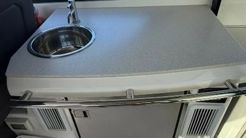 Slide: The Image of Galley Counter with Sink This image showcases the sleek and functional galley counter aboard the 2014 Regal 46 Sport Coupe. The countertop features a polished stainless steel sink and a modern faucet, ideal for meal prep and cleanup. The compact design maximizes space efficiency - 6857458