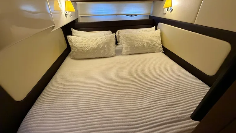 Slide: The Image of Cozy Forward Stateroom Experience comfort in the forward stateroom of the 2014 Regal 46 Sport Coupe. This inviting space features a plush double berth, accompanied by elegant wall sconces that provide a warm, ambient glow. Clean lines and soft fabrics create a serene environmen - 6857440