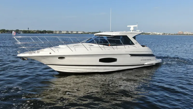 Slide: The Image of Starboard Side View of Sport Coupe This image showcases the sleek starboard side of the 2014 Regal 46 Sport Coupe, Serenity in the Sea. The yacht's modern design features a streamlined hull and expansive windows, enhancing both style and natural light inside. The hardtop roof offers protec - 6857483