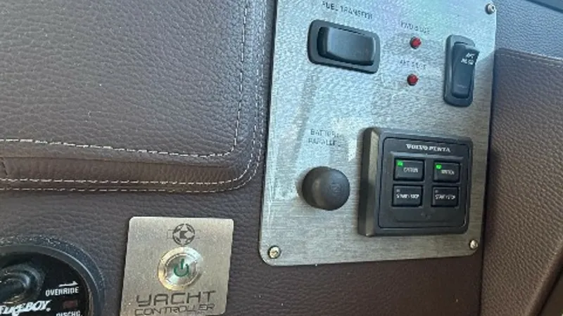 Slide: The Image of Helm Control Panel Close-Up This close-up view showcases the helm control panel of the 2014 Regal 46 Sport Coupe. The panel features advanced navigation and control systems, including a Volvo Penta engine interface and a yacht controller for precise maneuverability. The sleek, leath - 6857450